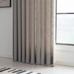 Cortina técnica gris instalada junto a una ventana